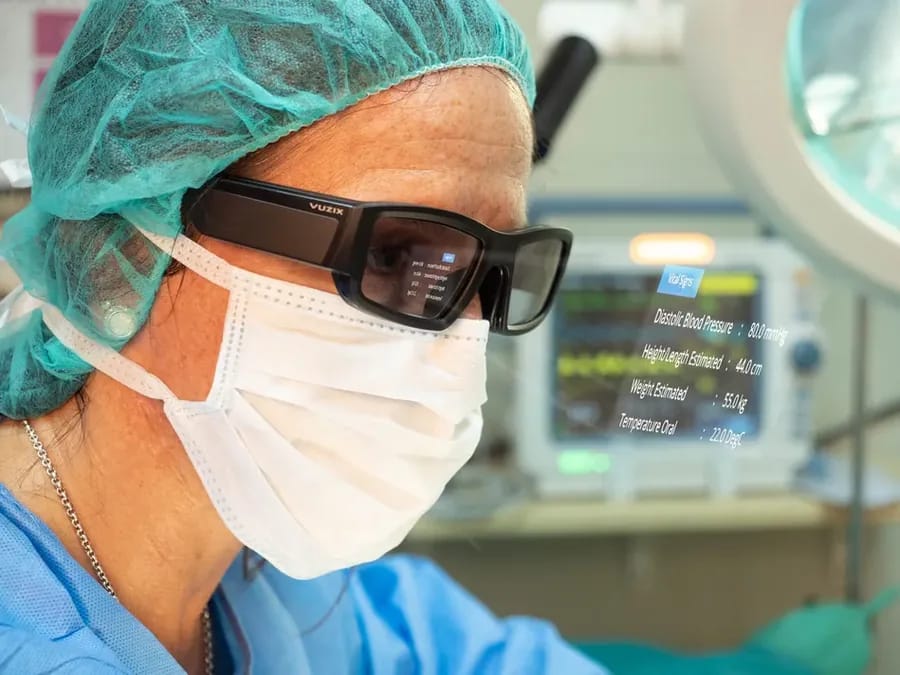 Surgeon wearing Vuzix AR smart glasses with patient data overlay in operating room